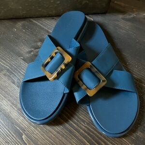 Olukai blue slide sandals with tortoise buckle